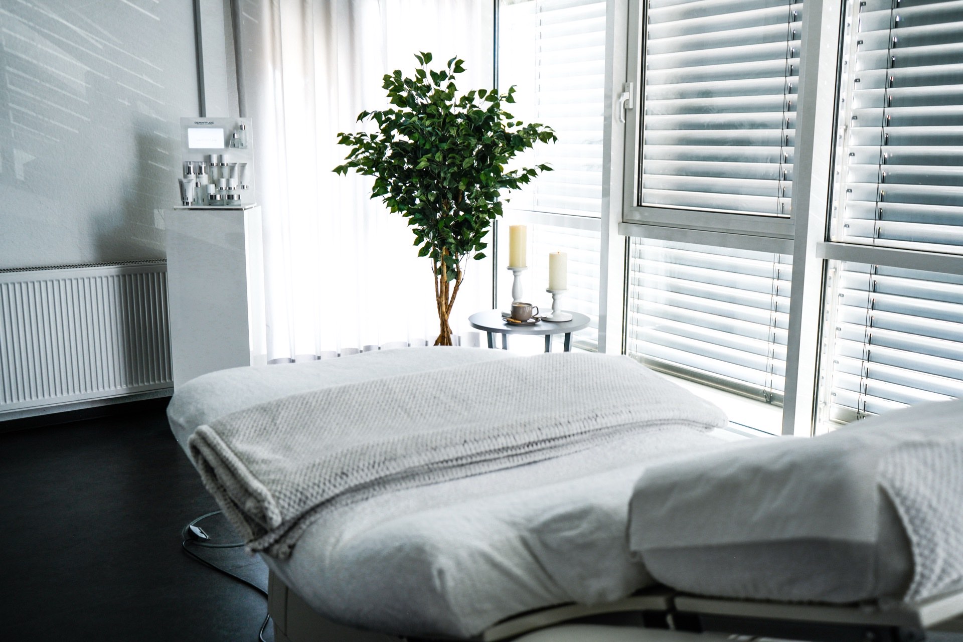 Behandlungsraum mit frisch bezogener Liege, Tageslicht und Grünpflanze — Beauty Secret by Alina, Paderborn