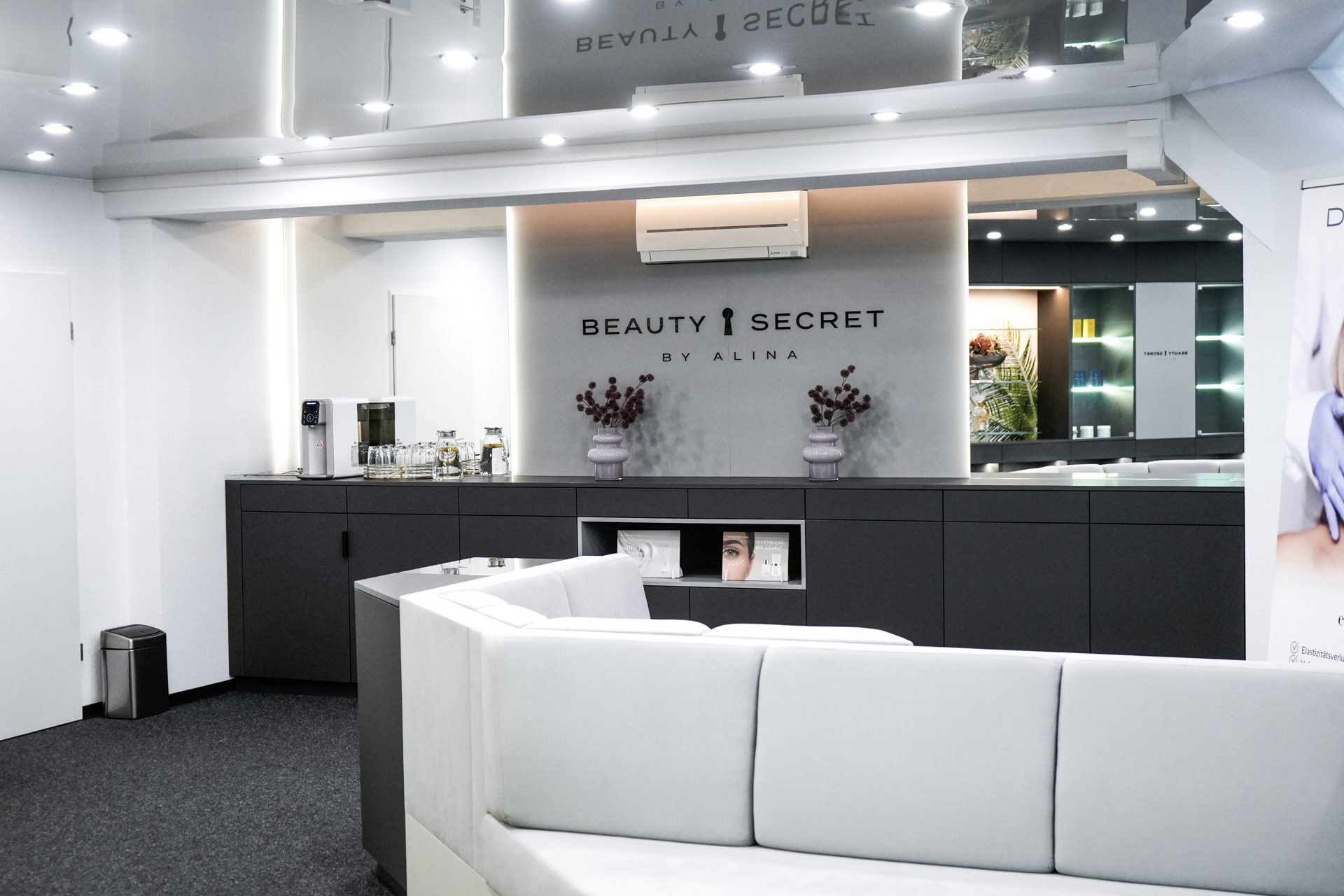 Empfangsbereich mit Logo-Wand und Lounge